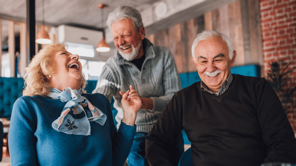Older adults talking together in a senior living lounge